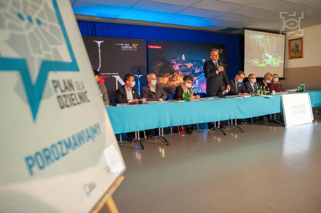 Lublin: zawieszono spotkania w ramach „Planu dla Dzielnic” 1 przedstawiciele urzedu miasta siedzacy za stolem. po lewej stronie fragment plakatu plan dla dzielnic.klowfqwibgpc785hlxs 2022 02 01 092142